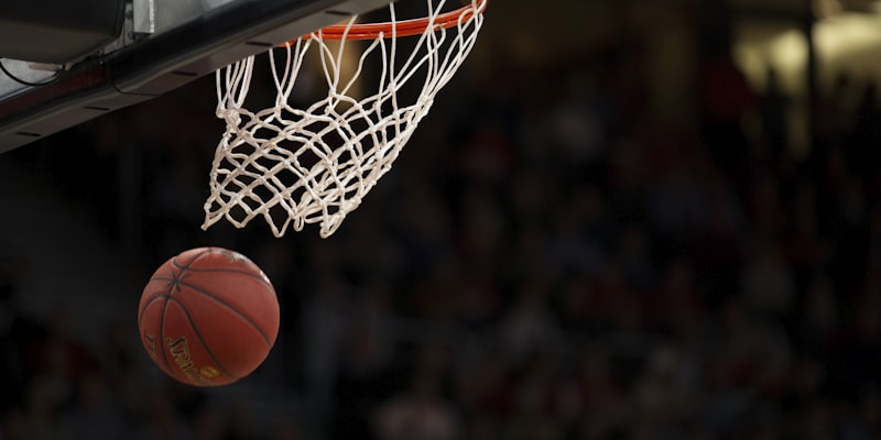 NBA篮球比赛中球员扣篮的精彩瞬间，灯光聚焦